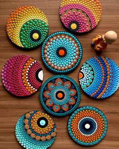 several colorful circles are arranged on a wooden surface with an egg in the middle and one circle is made out of beads