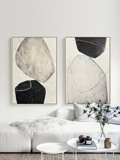 two black and white paintings on the wall in a living room