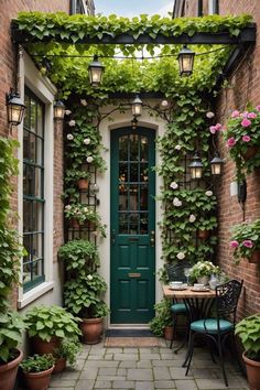 a green door surrounded by potted plants next to a table with chairs on it