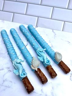 four blue toothbrushes with sea creatures on them sitting on a marble counter top