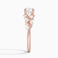 a rose - shaped diamond ring with leaves on the side, set in 18k rose gold