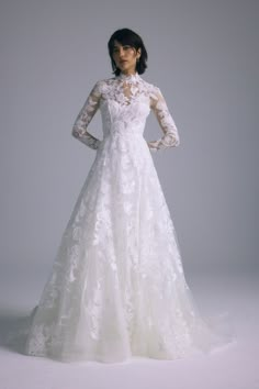 a woman in a white wedding dress with long sleeves