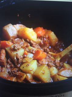 a crock pot filled with stew and potatoes