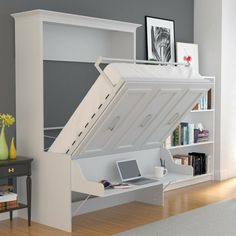 a white desk with a laptop on top of it and a large open bookcase