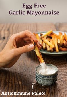 a person is dipping some fries into a small bowl with ranch dressing on the side