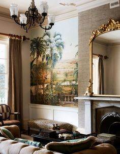 a living room filled with furniture and a fire place under a painting on the wall