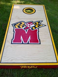 a cornhole board with the letter m on it