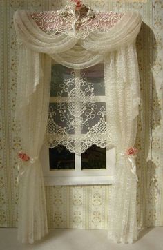 a white curtain with lace on it in front of a window