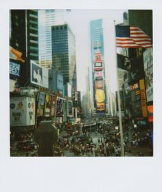 a city street filled with lots of traffic and tall buildings covered in billboards next to each other