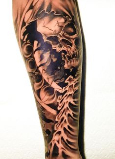 a man's leg with a skeleton and tree tattoo on the side of it