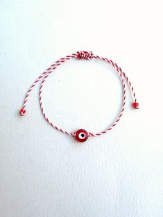 Martis bracelet, Waxed cord bracelet, March bracelets, Red and White, Twisted string, Enamel charm, Evil eye charm, Greek custom, Tradition The March bracelet is an ancient Greek custom. From the beginning of March, people wear a bracelet made of white and red twisted thread. According to the tradition, the March bracelet protects those from burning of the first sun of spring. The last day of March,the bracelet is left on trees so that swallows can use it for building their nests. The price is f Handmade Red Jewelry With Nylon Cord, Handmade Red Braided Bracelets With Nylon Cord, Handmade Red Braided Nylon Cord Bracelets, Red Adjustable Cord Bracelets, Red Nylon Cord Jewelry Perfect For Gifts, Handmade Red Nylon Cord Braided Bracelets, Red Adjustable Nylon Cord Bracelets, Red Nylon Cord Friendship Bracelet, Red Adjustable Friendship Bracelets As Gifts