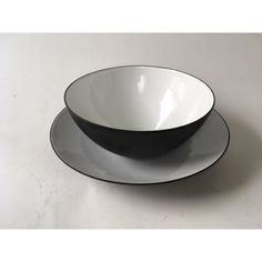 two black and white bowls sitting on top of each other