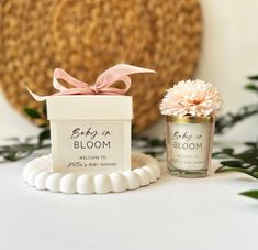 two small jars with flowers in them sitting on a table