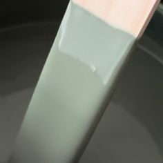 a toothbrush is sitting on top of a gray bowl with a pink and white handle