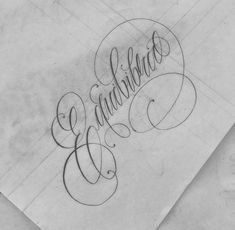 some type of lettering that is on top of a piece of paper with writing underneath it