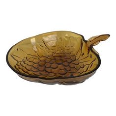 a yellow glass bowl with an animal design on the front and bottom, sitting on a white surface