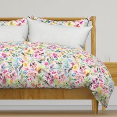 a bed with white pillows and floral comforter