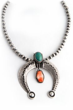 The traditional, sandcast, crescent shaped Naja pendant has been borrowed from the Moorish culture. Like a horseshoe, it symbolizes good luck. It is often found at the bottom of the classic squash blossom necklace. Navajo silversmith, Martha Cayatineto, created this piece by carving the shape into sandstone and pouring molten sterling silver into it. It was stamped with a Rain design and lightly oxidized for a vintage look. Beautiful Turquoise and Spiny Oyster stones were bezel set and a sterlin Naja Necklace, Naja Pendant, Rain Design, Crescent Shape, Squash Blossom Necklace, Squash Blossom, Spiny Oyster, Multi Stone, Native American Jewelry