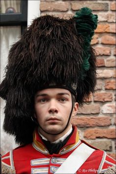 a man in a red uniform with a big furry hat on his head