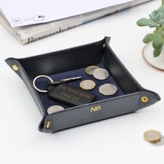 a black leather case with coins in it and a keychain on the side