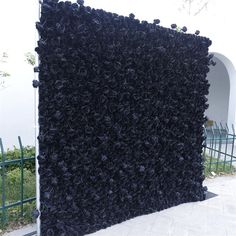 a large black piece of art sitting on top of a sidewalk