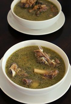 two white bowls filled with soup on top of a table