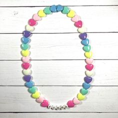 "You have just found the perfect gift for birthdays or Easter! This cute pastel, retro HEART necklace can come personalized or with hearts only. This 16\" stretchy necklace fits right over your head so it's easy to put on- no clasps needed. The matching bracelet is listed here: https://www.etsy.com/listing/909362079/kids-heart-bracelet-party-favor-girls?ref=shop_home_active_5&frs=1 Please check all selections and spelling prior to check out. Our custom jewelry is made to order so all sales a Personalized Playful White Necklace, Playful Personalized White Necklace, White Heart Necklace For Birthday And Valentine's Day, Cute Personalized Heart Necklace For Mother's Day, Fun Pink Necklace For Birthday, Cute Personalized Multicolor Necklaces, White Heart Charm Necklace For Birthday, Cute Multicolor Necklace For Birthday, Cute Multicolor Personalized Necklaces