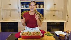 a woman is giving the thumbs up in front of a casserole dish