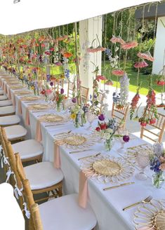 a long table set up with chairs and flowers