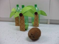 a coconut sitting on the floor next to two plastic bottles with palm trees in them