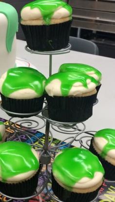 cupcakes with green and white frosting on a cake stand