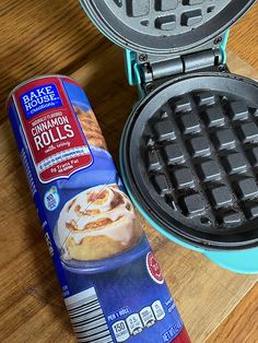 a waffle iron next to a carton of cinnamon rolls