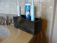 two toothbrushes are sitting in a holder on the sink counter