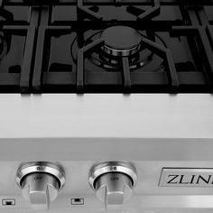 a stainless steel stove top with three burners and two knobs on the front