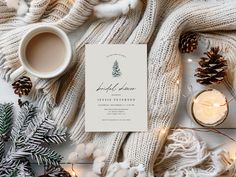 a white christmas card surrounded by pine cones and candles