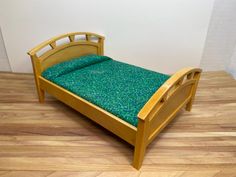 a small wooden bed sitting on top of a hard wood floor next to a wall