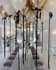 balloons are tied to the ceiling in an elegant room with white walls and flooring