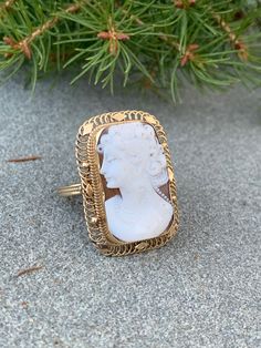 "This fabulous cameo ring is set in 14k yellow gold. It dates from the 1950s. Possessing entrancing whimsy, this carved conch shell cameo is beautifully detailed. The profile of the lovely woman has an enchanted expression about you. In a continuous flow of interlocking woven open work gold, he frame highlights the beautiful carved conch cameo profile. The ring measures 1 1/4\" x 3/4\". It weighs 7.83 grams. It is a size 8, but can easily be resized up or down. R 788 SIX MONTH LAYAWAY AVAILABLE" Victorian Cameo Rings For Anniversary, Victorian Gold Cameo Rings, Cameo 14k Gold Rings For Collectors, 14k Gold Cameo Rings For Collectors, Collectible 14k Gold Cameo Rings, Antique Cameo Yellow Gold Ring, Antique Yellow Gold Cameo Ring, Vintage Gold Cameo Ring, Antique Cameo Ring In Yellow Gold