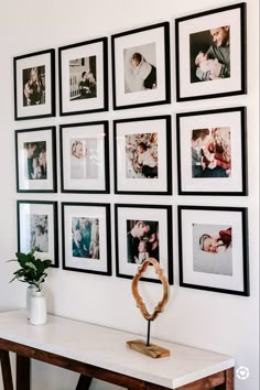 a white table topped with pictures and a vase filled with flowers