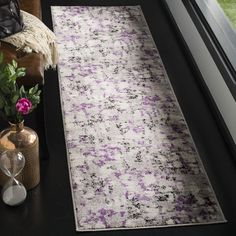 a purple and white rug sitting next to a window