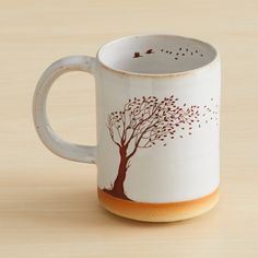 a coffee mug with a tree painted on it