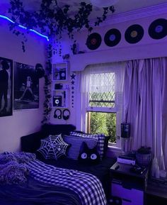 a bedroom decorated in black and white with purple lighting