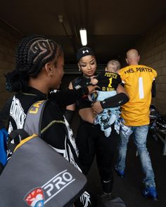 a group of people standing next to each other in a tunnel with one person holding a baby