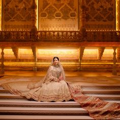 a woman sitting on some steps wearing a wedding dress