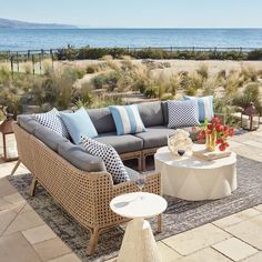 a living room filled with furniture next to the ocean