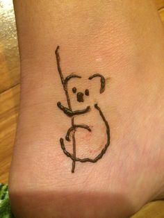 a small koala bear tattoo on the ankle