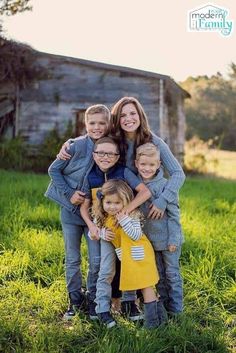 a family posing for a photo in front of an old barn with the sun shining on them