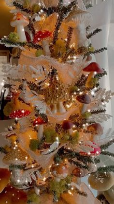 a white christmas tree with gold and red ornaments