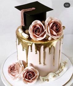 a graduation cake decorated with pink roses and gold drips on a white platter