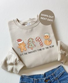 a white shirt with gingerbreads and snowmen on it next to a pair of jeans